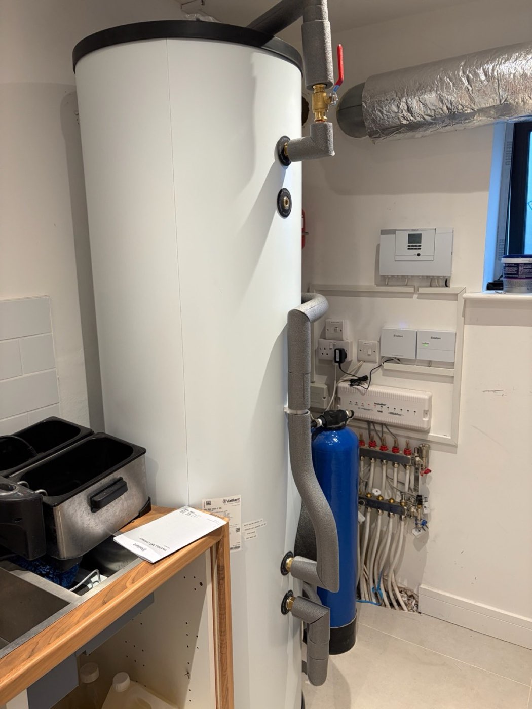 Hot water cylinder in a utility room with underfloor heating manifold