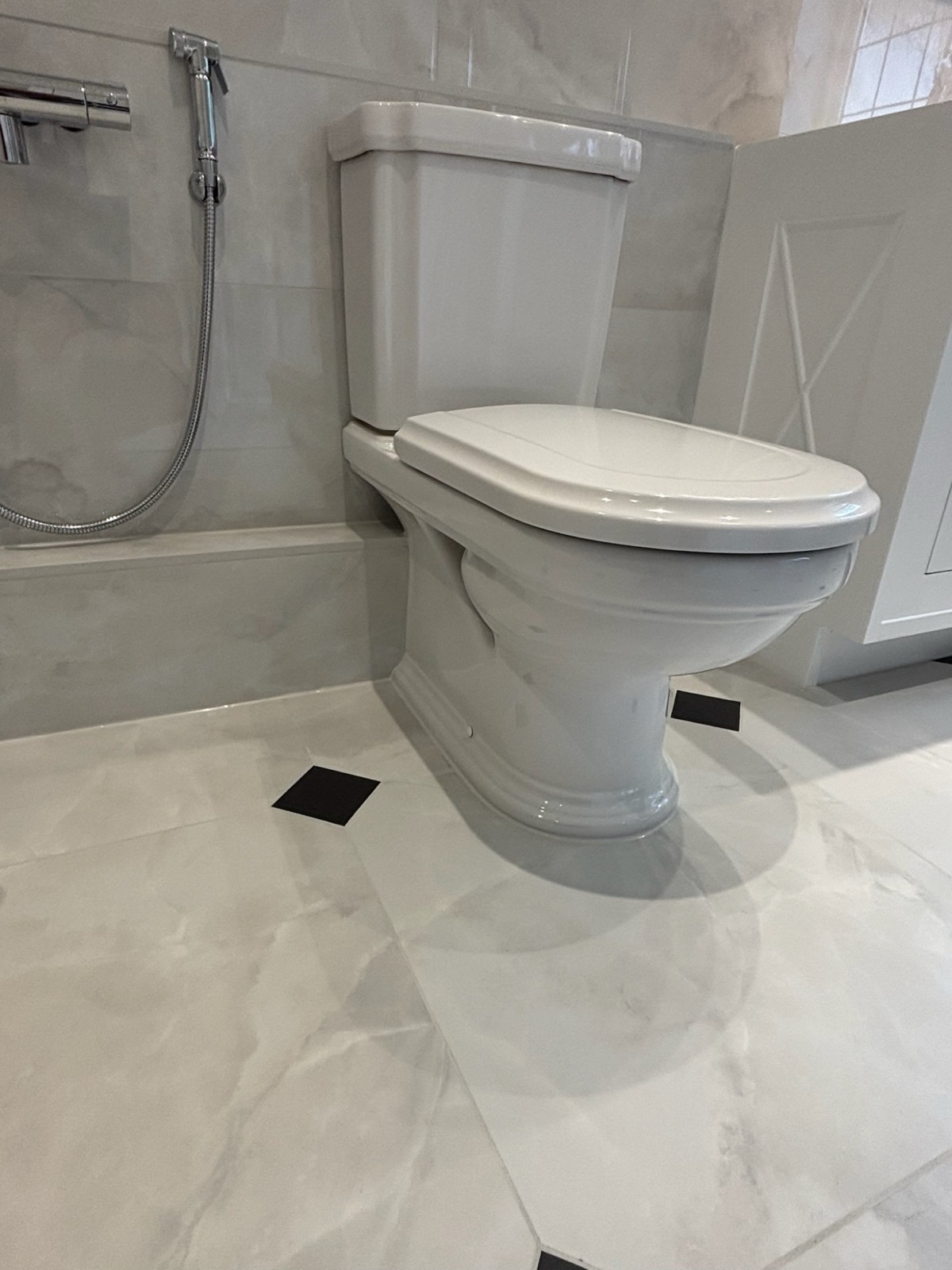 Traditional-style WC on a marble-tiled floor with black diamond inlays