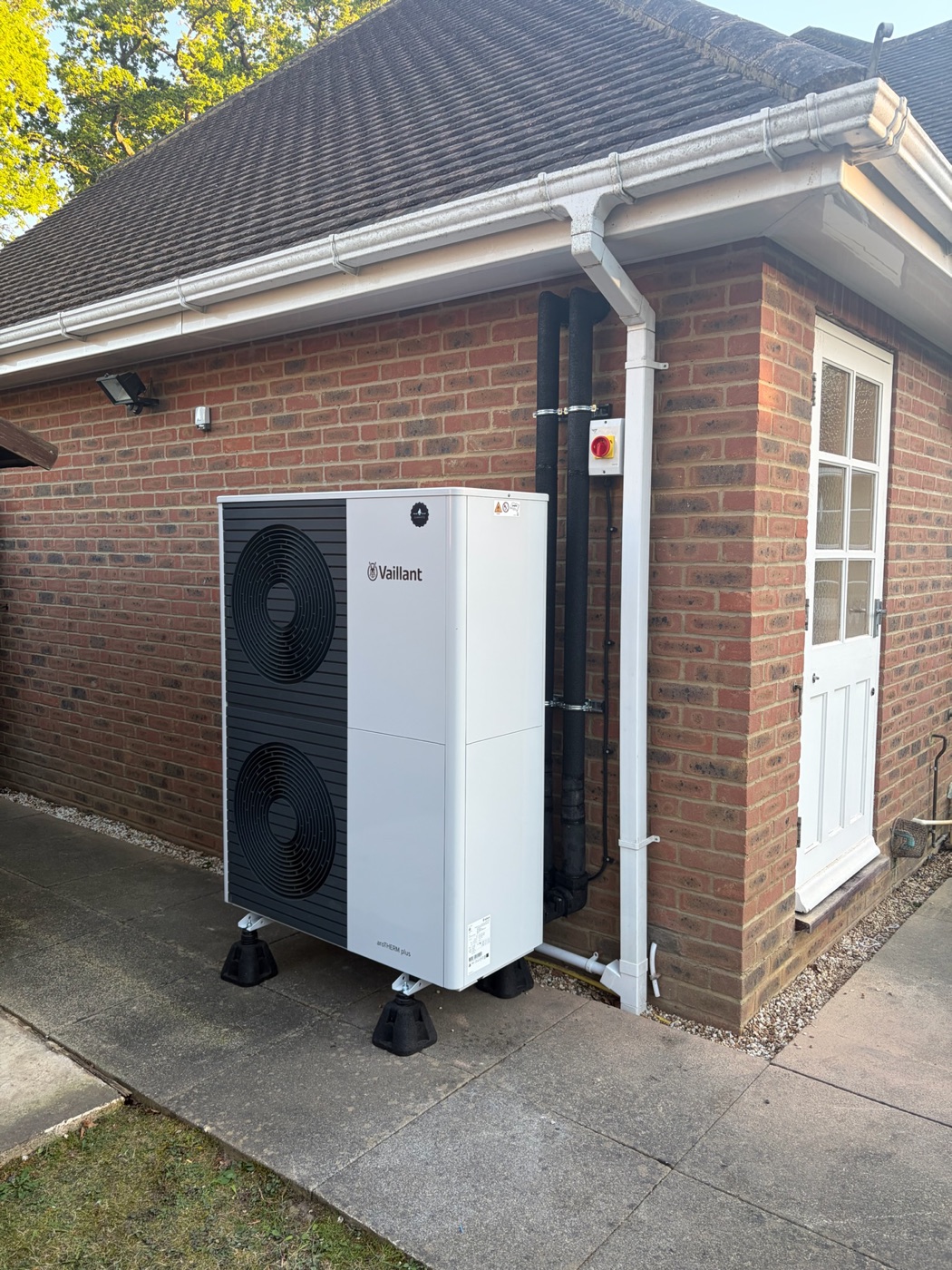 Vaillant air source heat pump fitted beside a brick house wall