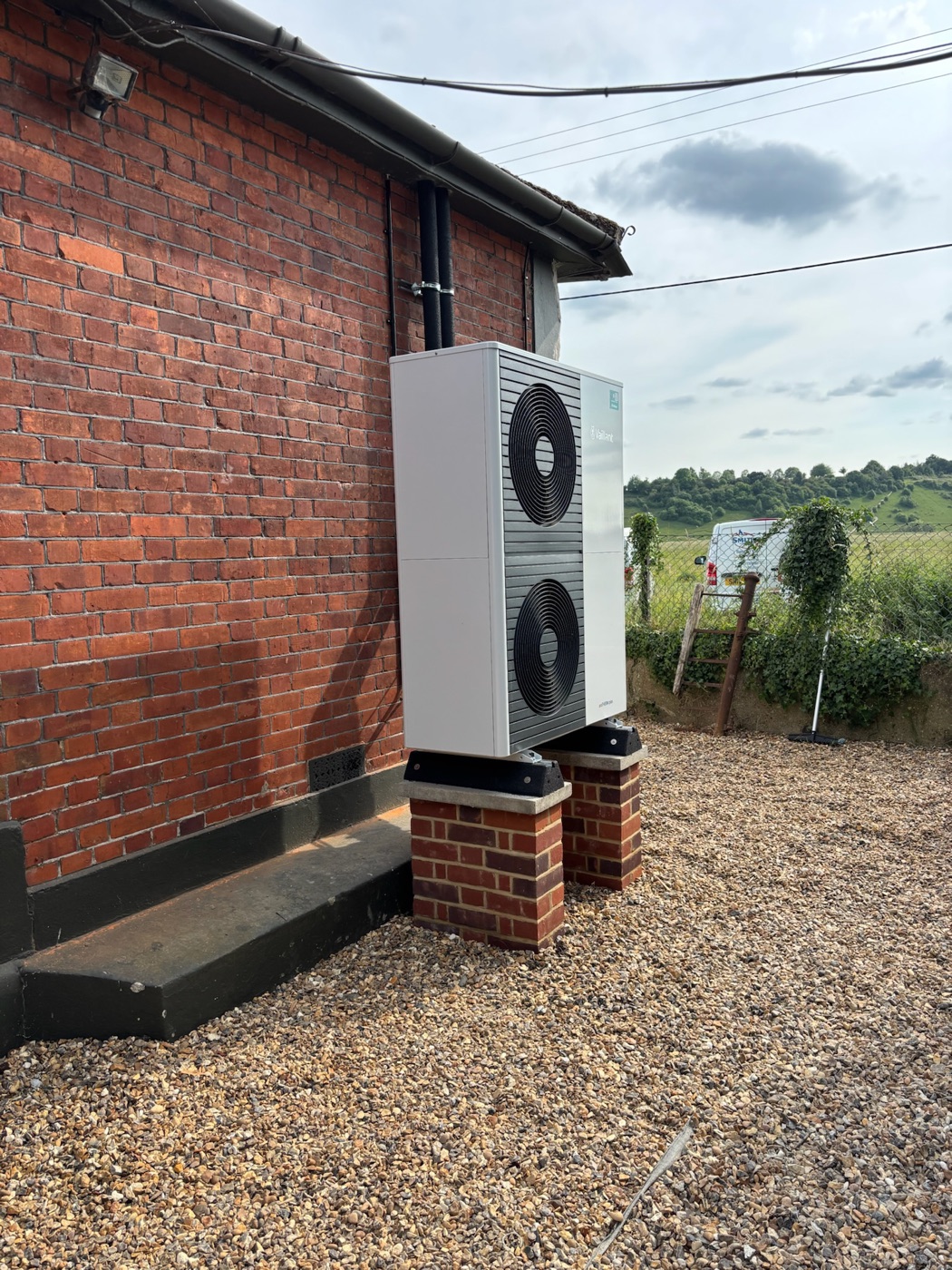 Air source heat pump on brick plinths at a rural property