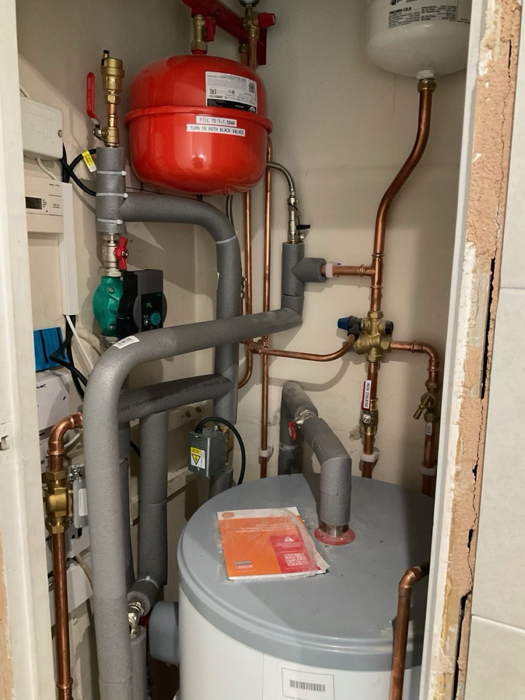 Heat pump cylinder with insulated pipework and expansion vessel